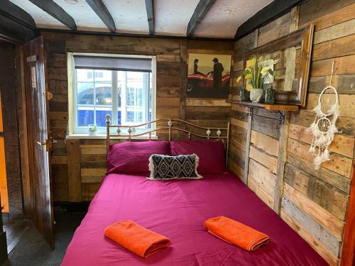 Cama grande en habitación con paredes de madera en Yarm cottages haystacks/hayloft, en Kirk Leavington
