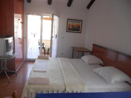 ein Schlafzimmer mit großem Bett und Fernseher in der Unterkunft Apartments Ivanka Bilo in Primošten