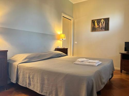 クレモナにあるAgriturismo Cascina Nuovaのベッドルーム1室(ベッド1台、ランプ付きテーブル付)