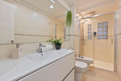 ein Badezimmer mit einem weißen Waschbecken und einem WC in der Unterkunft Luxury Apartment City Centre in Granada