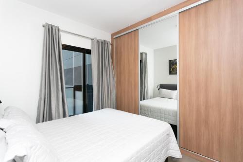 a bedroom with two beds and a mirror at VN Capote Valente 712 no coração de São Paulo in Sao Paulo