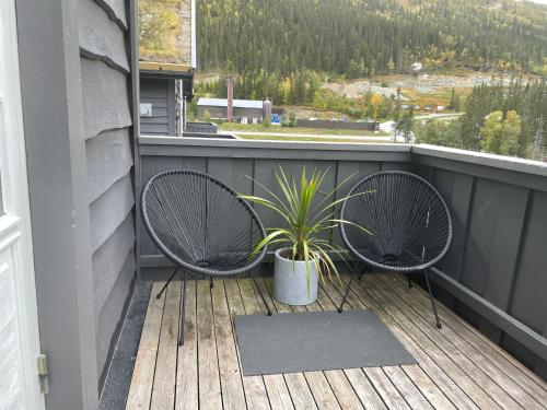 a balcony with two chairs and a potted plant at Tinden in Hemsedal