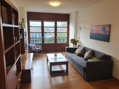 uma sala de estar com um sofá e uma mesa de centro em Luminoso piso con terraza y aparcamiento ESS01636 em Hondarribia