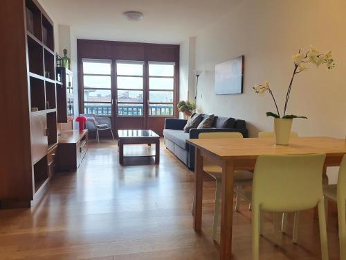 uma sala de estar com uma mesa e um sofá em Luminoso piso con terraza y aparcamiento ESS01636 em Hondarribia
