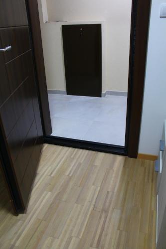a mirror in a room with a door and a wooden floor at Exceptional Suite in Čačak