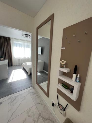 een badkamer met een grote spiegel en een slaapkamer bij Квартира Люкс на Поділлі in Vinnytsya