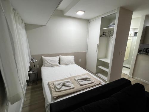 a small room with a bed with two towels on it at Flat Boa Viagem luxo in Recife