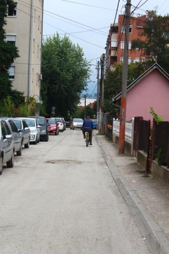 a person riding a bike down a street at Exceptional Suite in Čačak