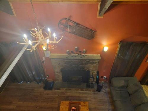 a living room with a fireplace and a chandelier at Camping Funhouse #3 in Tobyhanna