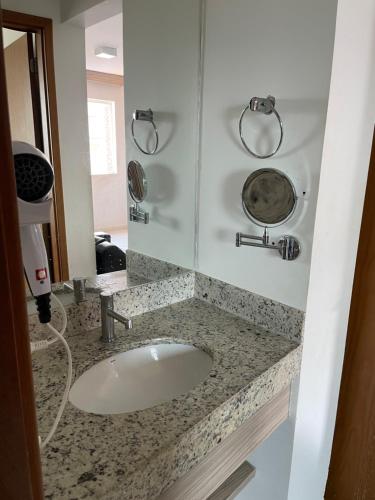 a bathroom with a sink and a mirror at Apartamento Riviera park in Caldas Novas