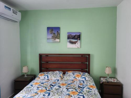 a bedroom with a bed and two night stands with lamps at Verano 2019 in Santiago de los Caballeros