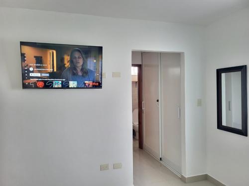 a living room with a tv on a wall at Verano 2019 in Santiago de los Caballeros