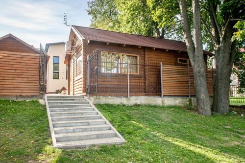 a wooden house with stairs in front of it at Kambarių nuoma Žasliuose in Žasliai