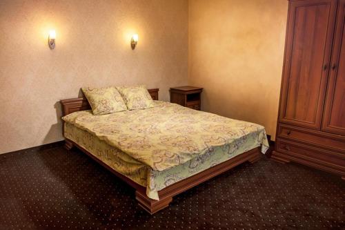 a bedroom with a bed and a wooden cabinet at Kambarių nuoma Žasliuose in Žasliai