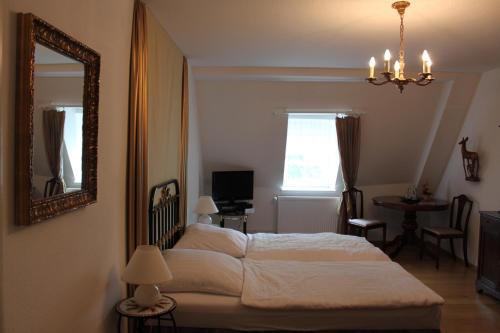 a bedroom with a bed and a mirror and a table at Schloss Hotel Wallhausen in Wallhausen