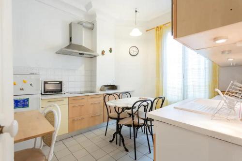 a kitchen with a table and chairs in a kitchen at J'aime Paris 1st in Boulogne-Billancourt