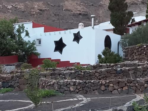 a wall with stars painted on it in front of a building at Centro Ave Fénix in Femés