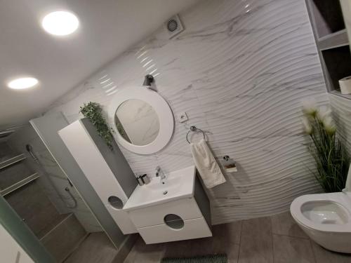 uma casa de banho com um lavatório, um espelho e um WC. em *Enjoy* em Sibenik