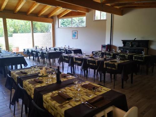 una habitación llena de mesas y sillas con copas de vino en Agrimar 2, en Rignano Flaminio