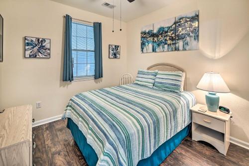 1 dormitorio con 1 cama y mesita de noche con lámpara en Ground-Floor Condo with Community Perks en Myrtle Beach