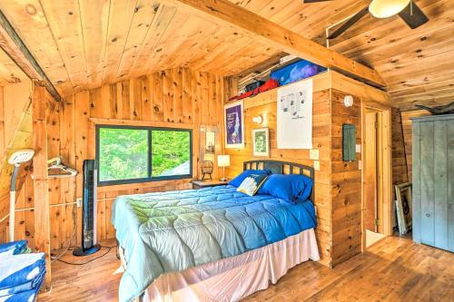 a bedroom with a bed in a wooden cabin at Dreamy Bucksport Hideaway on Freshwater Pond! in Bucksport