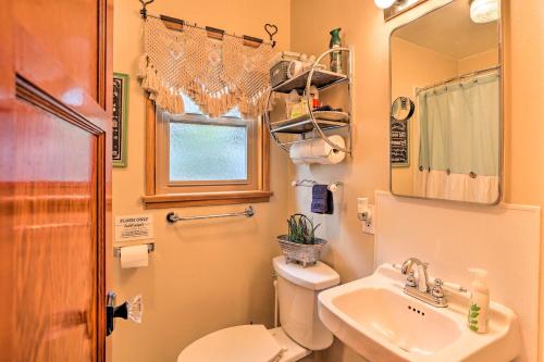 y baño con aseo, lavabo y espejo. en Wrightwood Cabin with Cozy Interior! en Wrightwood