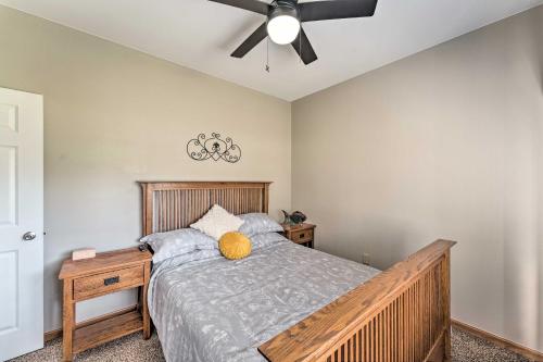1 dormitorio con cama de madera y ventilador de techo en Lake Mills Retreat 1 Mi to Beaches and Dining!, en Lake Mills
