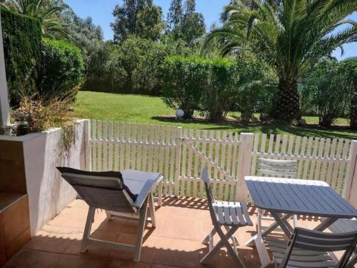 taras ze stołem, krzesłami i płotem w obiekcie Puerto Banus Apartment near beachfront, big sunny terrace, pool, tennis court, parking & movies projector w Marbelli