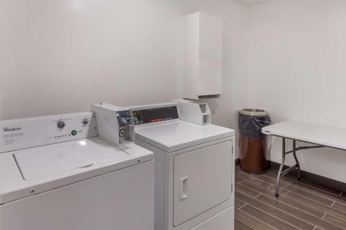 a white kitchen with a washing machine and a table at Best Western Logan Inn in Chapmanville