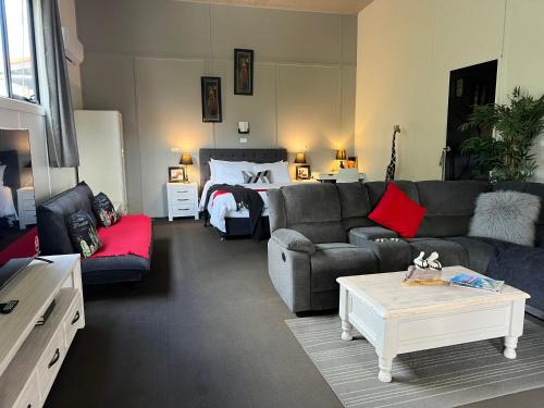 sala de estar con sofá y cama en Longhorn Ranch Apartments, en Orbost