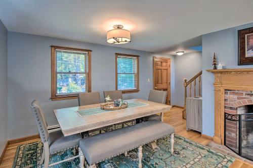 a dining room with a table and chairs and a fireplace at Charming Saco Home with Deck, 5 Mi to Beach! in Saco