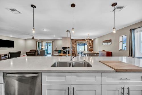 a kitchen with a sink and a living room at Quiet Contemporary Executive 4BD, 3BA Estate with Pool in Tempe