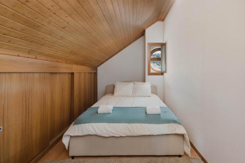 a bedroom with a bed with a wooden ceiling at Retiro da Serra in Penhas da Saúde