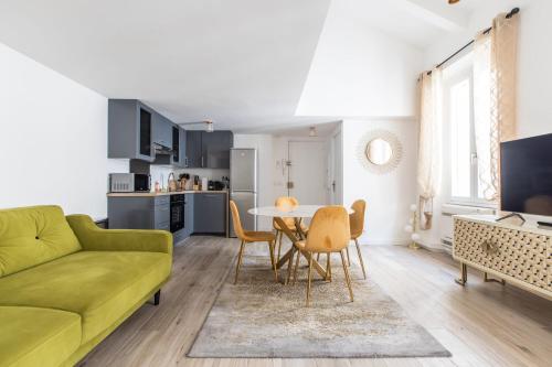 un salon avec un canapé vert et une table dans l'établissement LB Vacation Rentals I Beautiful City Center & Renovated Duplex Minutes from Beaches & Palais, à Cannes