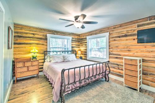 a bedroom with a bed and a ceiling fan at 1 Mi to Lake Chic Arizona Cabin with Large Porch! in Lake of the Woods
