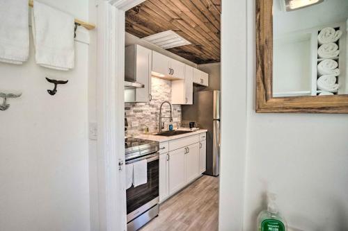 a kitchen with white cabinets and a sink at Chic Cottage with Private Yard Steps to Beach! in Colonial Beach