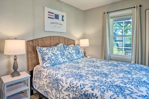 a bedroom with a blue and white bed with a window at Chic Cottage with Private Yard Steps to Beach! in Colonial Beach