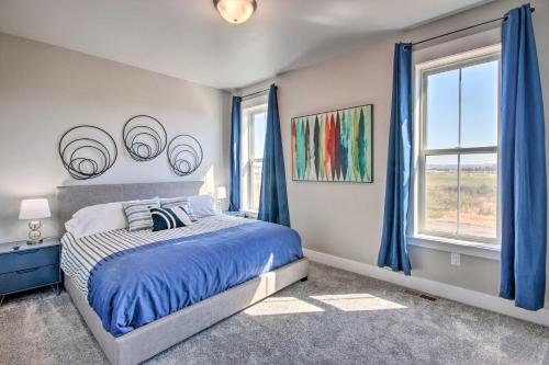 a bedroom with a bed with blue curtains and a window at Family-Friendly Home, 5 Mi to Downtown Billings! in Billings