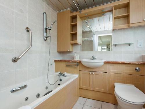 a bathroom with a sink and a tub and a toilet at The Penthouse in Dartmouth