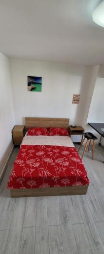 une chambre avec un lit rouge dans une pièce dans l'établissement Self check-in Studio 22 Bulevardul Oltenia, à Craiova