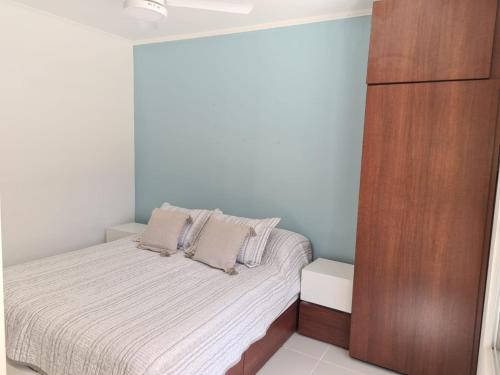 - une petite chambre avec un lit et une armoire en bois dans l'établissement Apart Esperanza, à Esperanza