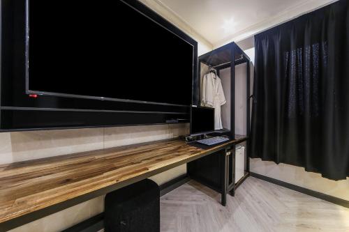 a large flat screen tv on the wall of a room at Masan First Class Hotel in Changwon