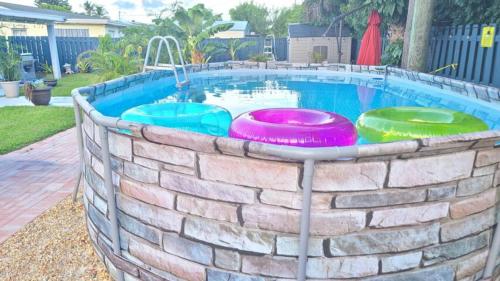 una piscina con cuatro frisbees en una pared de ladrillo en Palm Springs 3-Bedroom 2-Bath 5 Miles to the Beach, en Lake Worth