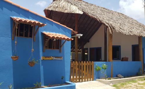 a blue house with a thatched roof at Pousada Yemanjá Cunhaú in Barra do Cunhau