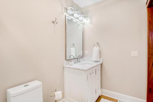 Baño blanco con lavabo y espejo en Port Angeles Water View Loft, en Port Angeles