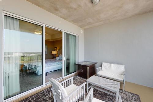 a room with a balcony with a bed and a chair at The Wharf 805 in Orange Beach