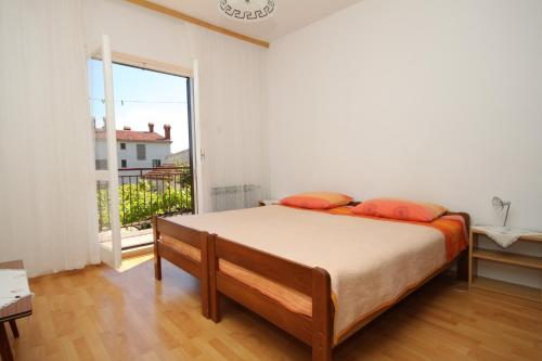 ein Schlafzimmer mit einem Bett und einem großen Fenster in der Unterkunft Apartment Pula 7647a in Pula