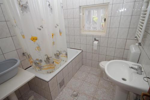 ein Badezimmer mit einer Badewanne, einem Waschbecken und einem Duschvorhang in der Unterkunft Apartment Pula 7647a in Pula