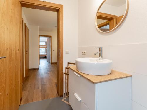 baño con lavabo y espejo en la pared en Chalet Heimelig XL en Saalbach Hinterglemm