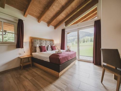 a bedroom with a bed and a large window at Chalet Anna XL Leogang in Leogang